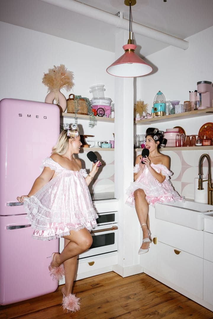 Jesse and Emily in the kitchen with microphones, Jesse on the counter