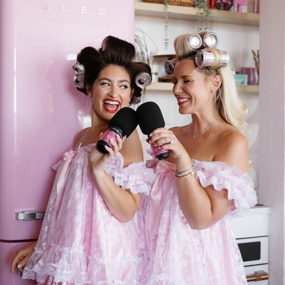 Jesse and Emily in front of fridge holding microphones